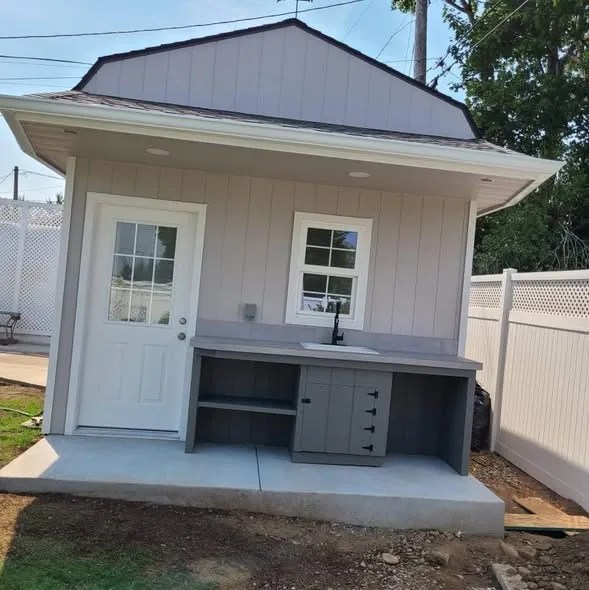 Finished gray shed with outdoor sink counter