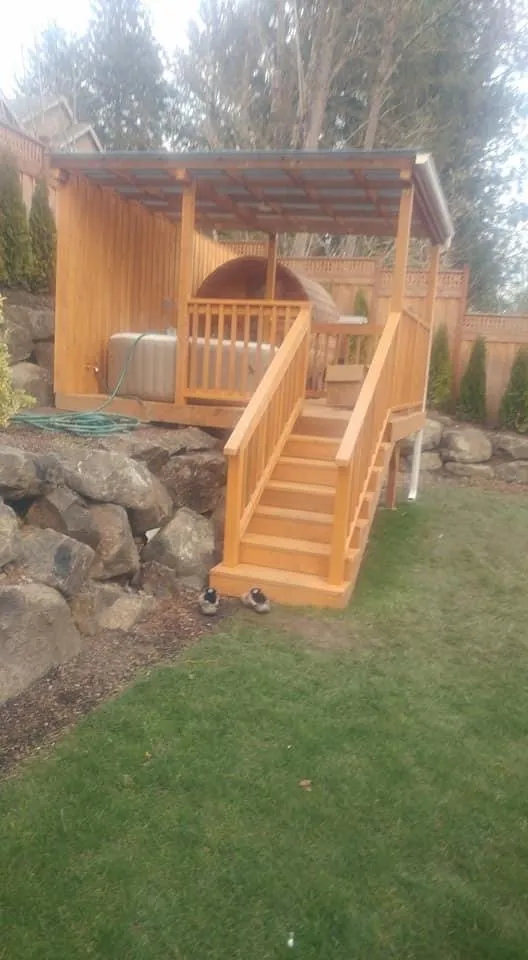 Sauna pavilion with wood stairs beside rock landscaping