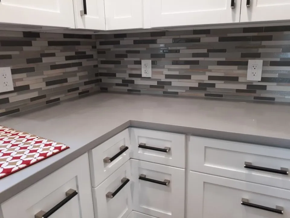 Gray mosaic backsplash wrapping a kitchen corner