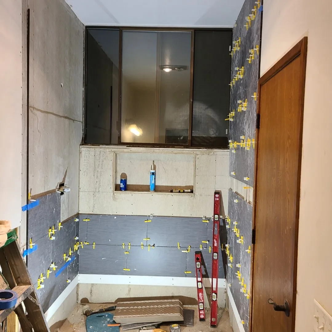Shower wall tile being set with spacers during installation